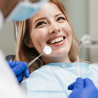 Woman smiling during dental checkup and teeth cleaning in Dallas