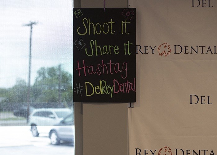 Chalk sign reading shoot it share it hashtag Del Rey Dental