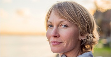 Smiling woman with short blonde hair at the beach