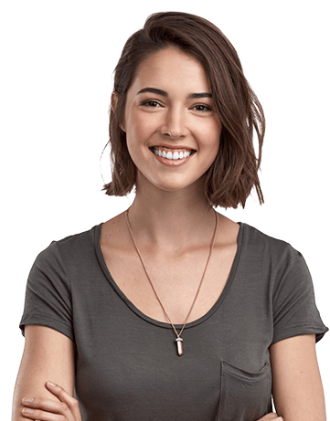 Woman with chin length brown hair wearing a gray T shirt smiling with arms crossed