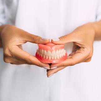 Lady presents dentures to viewer