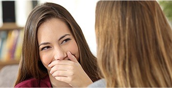 a woman covering her face and peeking through her fingers