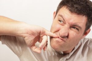 Annoyed man trying to remove food from his teeth